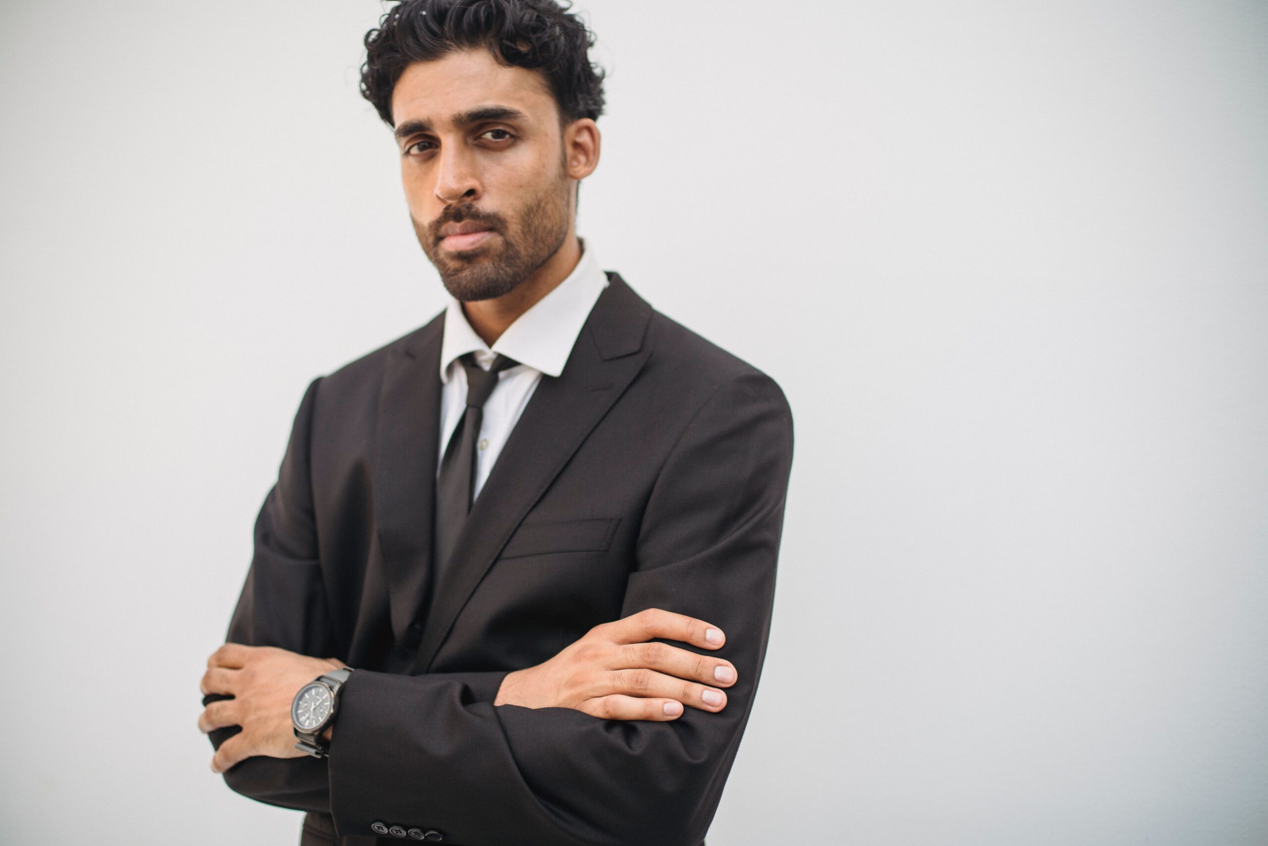 Home Portrait of a confident young man in a suit with arms crossed.